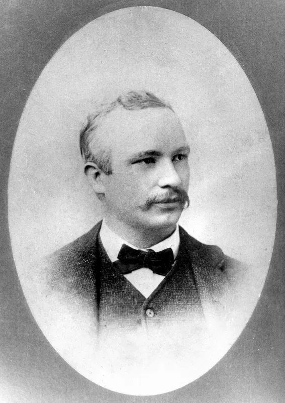 Black and white oval portrait of Peter J. McGuire with a moustache, in a suit and bow tie
